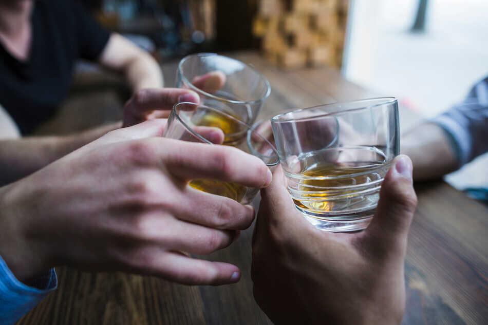 close-up-hands-toasting-whisky-glasses (1)